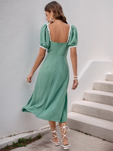 Detailed back view of a grass green dress with lace trim, puff sleeves, and a square neckline