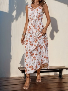 Close-up of white V-neck maxi dress featuring orange floral print and tassel drawstring waist