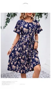 Détail d'une robe fleurie bleu marine avec manches cloche et ceinture à nouer