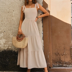 Elegant beige backless maxi dress with shoulder bows and tiered skirt design