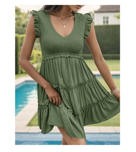 Detail of the smocked bodice and tiered ruffled hem on a dark green summer V-neck dress