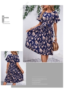 Détails d'une robe mi-longue fleurie bleu foncé avec manches à volants et jupe plissée
