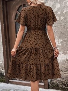 Rear view of brown polka dot dress featuring layered tiered skirt and ruffle sleeves