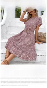 Detailed view of reddish-brown polka dot dress with waist belt and button front