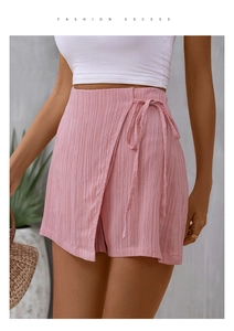 Detail view of pink high-waisted wrap skort with textured fabric and drawstring waist