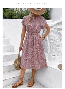 Detail of summer short sleeve dress featuring polka dot print, front buttons and waist belt