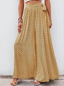 Détail d'un pantalon large taille haute avec imprimé géométrique jaune et cordon