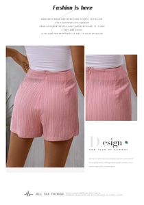 Detail of pink high-waisted shorts featuring vertical crinkle texture and invisible back zipper