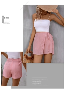 Detail view of pink high-waisted wrap skort with textured fabric and side bow tie