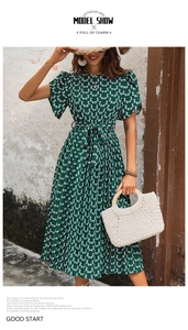 Robe plissée vert foncé avec imprimé floral blanc, ceinture nouée et manches bouffantes
