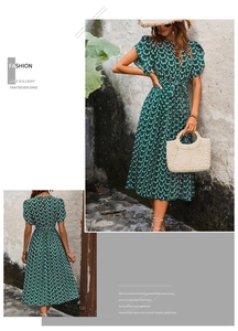 Détail d'une robe plissée vert foncé à fleurs avec manches volantées et taille nouée