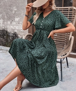 Detail view of the V-neckline with white buttons on the green polka dot summer dress