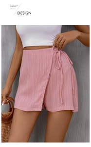 Detail of pink wrap skort featuring textured crinkle fabric and side tie design