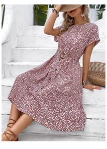 Detail of short-sleeved polka dot dress featuring button-front and belted waist
