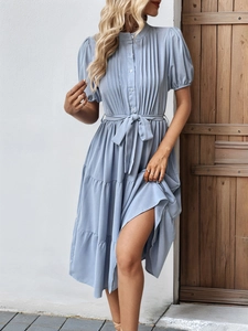 Détail de robe bleue claire à volants avec poitrine plissée et col montant à boutons