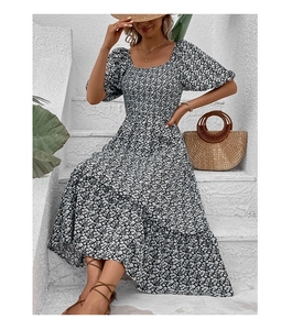 Detail of floral puff sleeve dress with tiered skirt and straw bag in garden setting