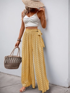 Détail du pantalon large à taille haute avec motifs géométriques jaunes et ceinture nouée