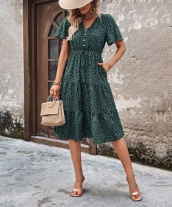 Close-up of dark green polka dot dress with v-neck, button details and ruffled sleeves