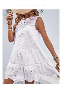 Detail von weißem ärmellosem Boho-Kleid mit Blumenstickerei und Quasten am V-Ausschnitt