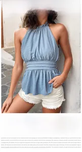 Detailansicht eines blauen Halter-Tops mit Rüschenkragen und strukturierter Punkt-Prägung