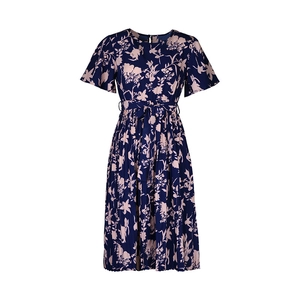 Détail d'une robe fleurie pour femme avec jupe plissée et nœud à la taille en bleu marine