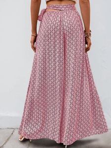 Détail du pantalon large à taille haute avec imprimé géométrique rose et blanc et nœud