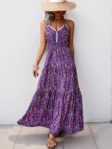 Détail d'une robe maxi bohème avec décolleté en V profond, motifs floraux et dentelle