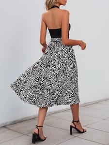 Detail of a leopard print maxi skirt and black halter neck knit top on a model