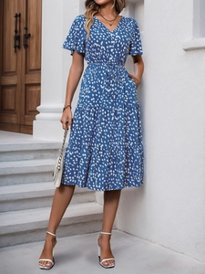 Detail of V-neckline and ruffled sleeves on a blue floral summer dress with lightweight fabric