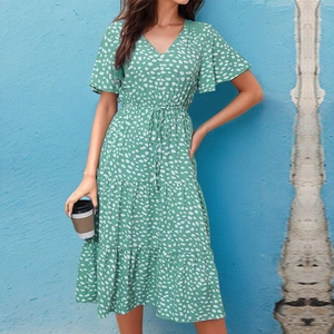 Detailed view of green floral dress with V-neckline, buttons and tiered ruffled hemline