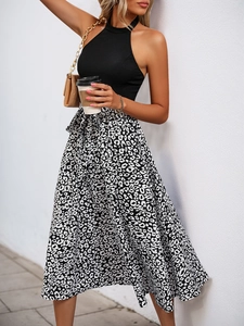 Detail of a chic summer outfit featuring a black halter neck top and leopard print skirt