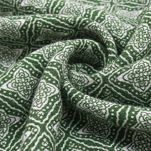 Gros plan sur tissu bohème vert à imprimé floral avec plis doux et texture