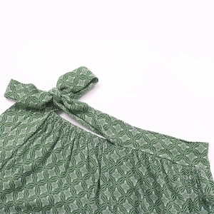 Détail du nœud papillon à cordon et du col plissé sur le pantalon vert à imprimé géométrique