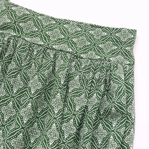 Gros plan sur le motif floral géométrique vert et blanc avec détails plissés de couture