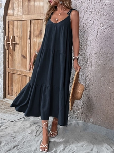 Detail of a tiered black cotton linen maxi dress with V-neck and spaghetti straps