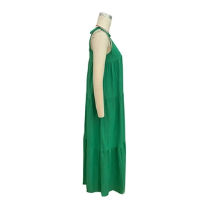 Detailed macro view of the pleated texture and tiered layers of this green maxi dress