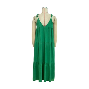 Detail of green tiered maxi dress showing slim straps and textured summer fabric
