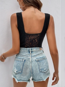 Vue détaillée du haut en dentelle noire dos nu et du short en jean effiloché sur mannequin