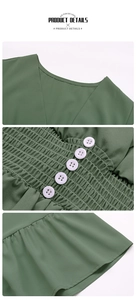 Detail view of V-neckline and smocked waist with white buttons on green dress