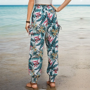 Détails d'un pantalon cargo à taille haute avec imprimé tropical et poches latérales à rabat