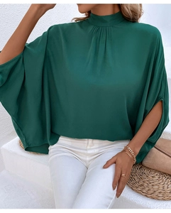 Detail of elegant dark green high neck blouse with split cuffs and batwing sleeves