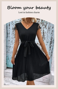 Detailed view of black V-neck pleated dress with lace sleeves and elegant waist bow tie