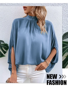 Detail of light blue mock neck satin top featuring elegant split batwing sleeves design