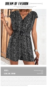 Detail of V-neck floral romper featuring a black buckled waist belt and short sleeves