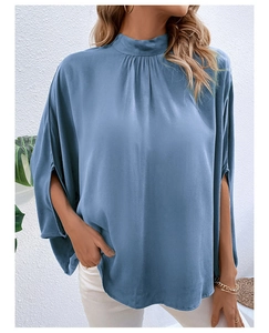 Detail of grey-blue blouse showing ruffled high neck and elegant split batwing sleeves