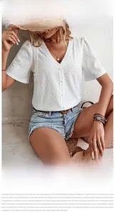 Close-up of white eyelet embroidery cotton fabric with V-neckline and button details