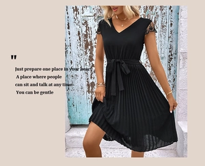 Close-up of black V-neck pleated dress with intricate lace sleeve details and bow belt