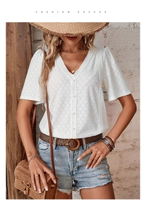 Close-up of white V-neck shirt with intricate eyelet embroidery and lace detailing