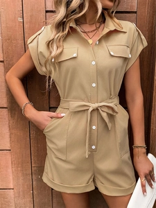 Detail of khaki romper featuring shirt collar, button-up front, and tie-waist belt