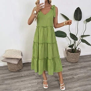 Close-up of grass green cotton linen dress featuring V-neck and bow-tie shoulder straps